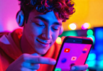 An enthusiastic young musician uploading a series of three engaging and colorful YouTube Shorts to a smartphone, each showcasing different genres, with vibrant visual effects that pop off the screen i